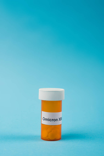 Jar with pills and omicron xbb lettering on blue background  - Zdjęcie, obraz
