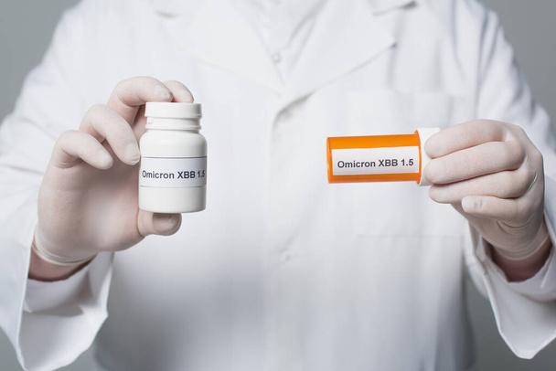 Cropped view of blurred doctor holding jars with pills with omicron xbb lettering isolated on grey  - Fotoğraf, Görsel