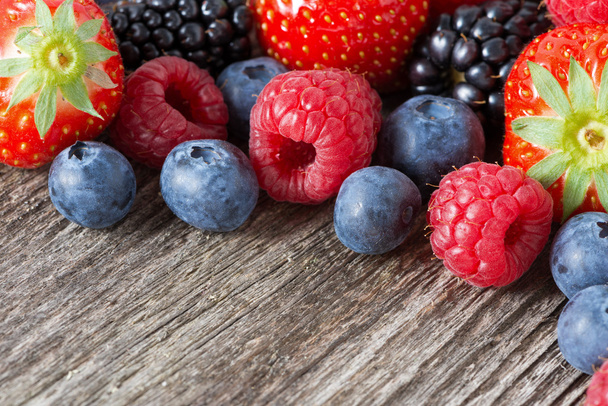 сортированные свежие сочные ягоды на деревянном фоне, горизонтальные
 - Фото, изображение