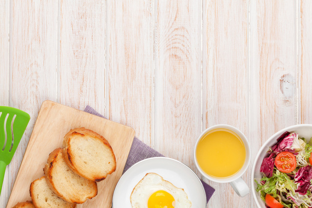 Здоровий сніданок зі смаженим яйцем, тостами та салатом
 - Фото, зображення
