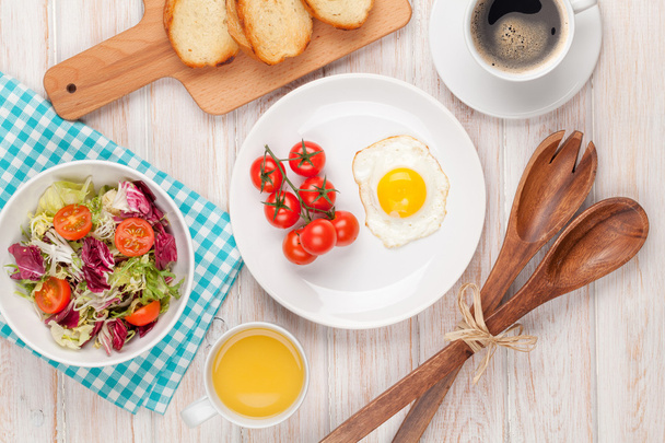 Desayuno saludable con huevo frito, tostadas y ensalada
 - Foto, imagen
