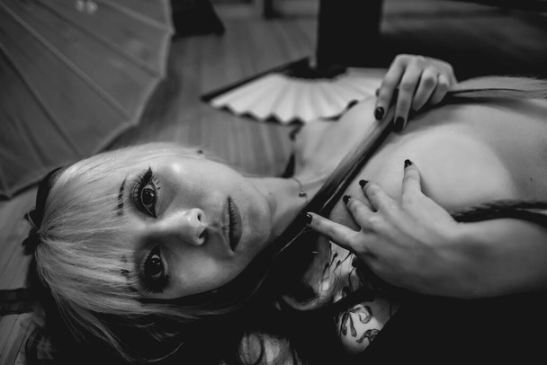 Beautiful, slim, young and sexy girl with blonde locks, small and sexy black kimono and panties, and shibari ties and knots on the body, in a traditional japanese room (in black and white) - Fotoğraf, Görsel