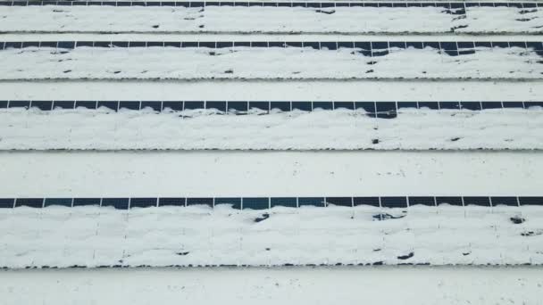 Aerial view of sustainable electrical power plant with solar photovoltaic panels covered with snow in winter for producing clean energy. Concept of low effectivity of renewable electricity in north. - Materiaali, video