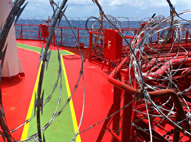 Barbed wire is twisted on board the tanker to protect against pirate attacks when sailing in dangerous areas of the seas and oceans. - Foto, Bild