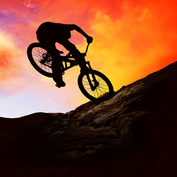 Silhouette of a man on muontain-bike, sunset - Foto, imagen