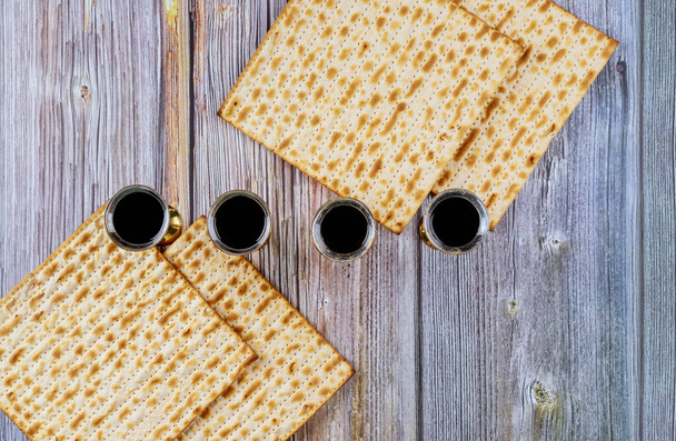 Κατά την προετοιμασία για τον εορτασμό του Πάσχα, matzah σερβίρεται με kiddush τέσσερα φλιτζάνια κόκκινο κρασί kosher - Φωτογραφία, εικόνα