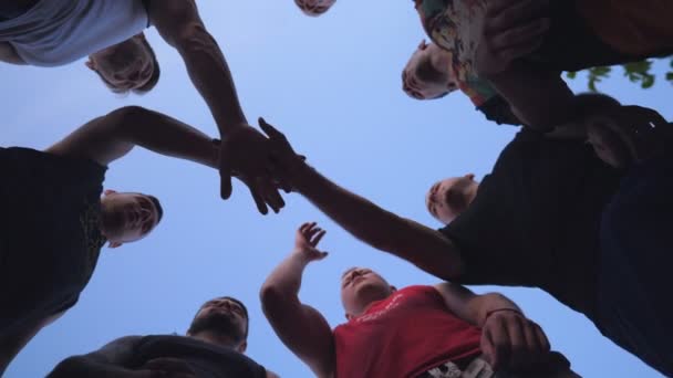 Молоді спортсмени складають руки один за одним в єдності. Група найкращих друзів кладуть руки в центр кола і піднімають їх на блакитне небо. Концепція дружби та командної роботи
. - Кадри, відео