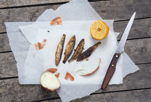 Horizontal composition of fried smelt fish with onion and lemon - Fotoğraf, Görsel
