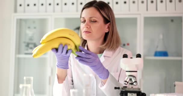 Зосереджена жінка-хімік, яка здійснює контроль якості бананових продуктів. Перевірка харчування в мікробіологічній лабораторії
 - Кадри, відео