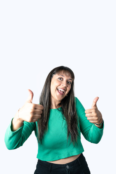 Happy Latin young woman showing thumbs up sign with both hands on white background. Vertical photography with copy space - Foto, Imagem