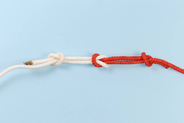 Rope reef knot, also known as square or double knot with overhand stopper knots on a blue background - Photo, image
