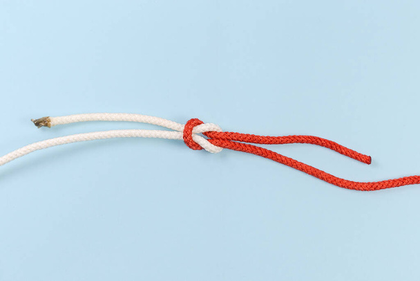 Rope reef knot, also known as square or double knot on a blue background - Fotoğraf, Görsel