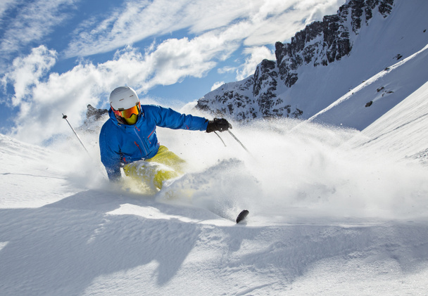 Esquiador esquiando cuesta abajo en las altas montañas - Foto, Imagen