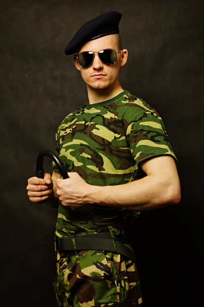 Military man holds nightstick at hand - Foto, Bild