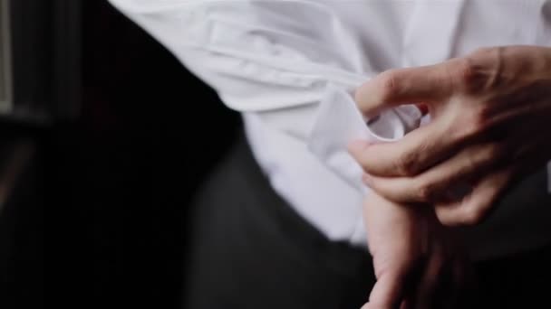 Man puts cufflinks on sleeves of white shirt. Close-up - Footage, Video