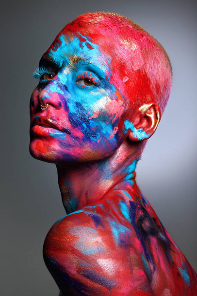Paint to the way your heart sings. an attractive young woman posing alone in the studio with paint on her face and body - Valokuva, kuva