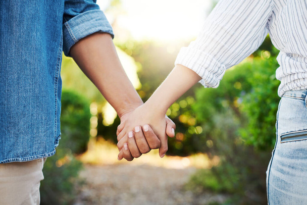 Рука в руці. лагідна невпізнавана пара, що йде рукою у своєму дворі вдома
 - Фото, зображення