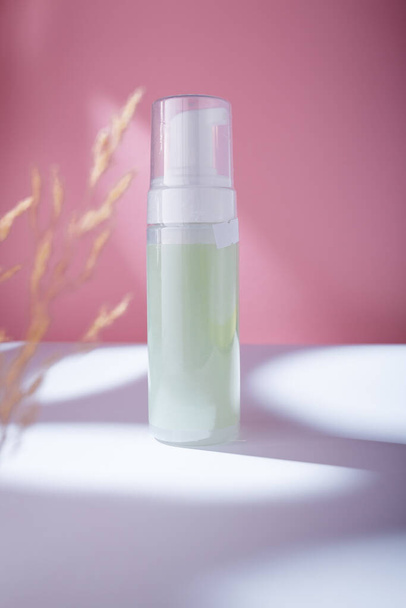 Foam care cosmetics green bottle on pink backdrop, mockup template. Gentle intimate area cleanser for PH balance with lactic acid, no brand - Foto, Bild