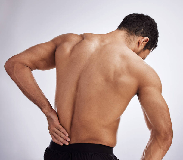 I may have pulled a muscle. a man experiencing back pain against a studio background - Foto, Bild