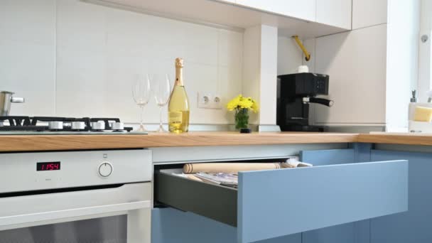 На современной сине-белой кухне закрывают ящик с кухонным гарнитуром - Кадры, видео