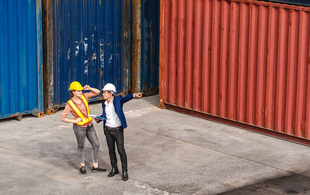 Професійний інженер-контейнер вантажопідйомної команди в шоломах, що працюють стоячи і використовуючи контрольний пакет Walkie Talkie в контейнері для завантаження.логістичний транспорт та експорт бізнес-індустрії
 - Фото, зображення