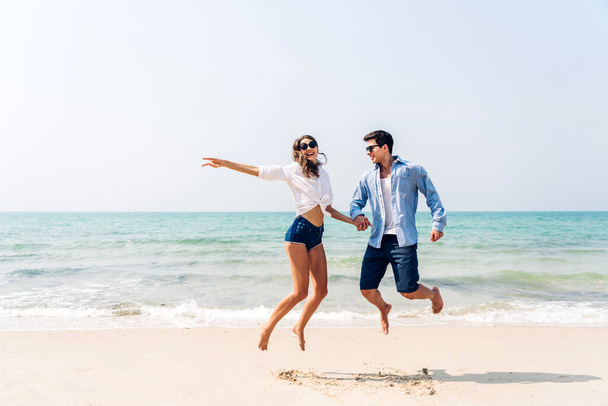 Отдых романтическая любовь молодая счастливая улыбка пара в медовый месяц путешествия поездки поездки, стоя на песке на голубом пляже моря весело и расслабляясь вместе на тропическом пляже. - Фото, изображение