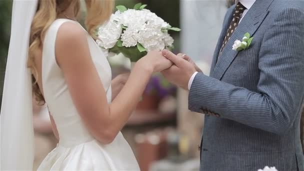 新郎は、花嫁の指に結婚指輪を置きます。花嫁の指にリングを置く、 - 映像、動画
