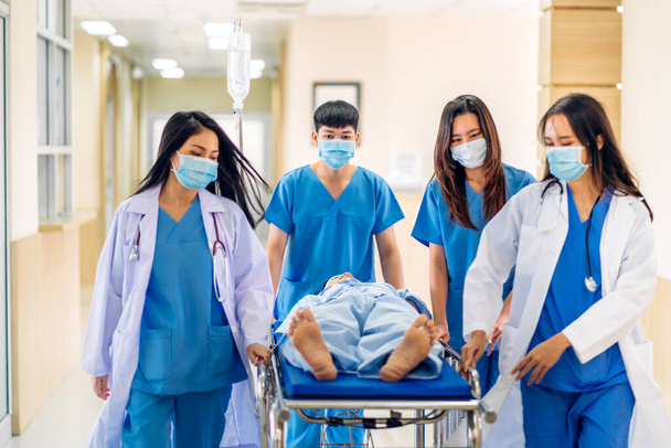 Ryhmä ammatillinen lääkäri joukkue ja avustaja stetoskooppi yhtenäinen ottaen vakavasti loukkaantunut koomapotilas leikkaukseen ensiapuun sairaalassa.terveydenhuollon käsite - Valokuva, kuva