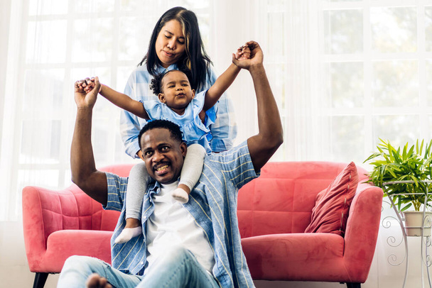 Portrait of enjoy happy love black family african american father and mother with little african girl child smiling and play having fun moments good time in room at home - Photo, Image