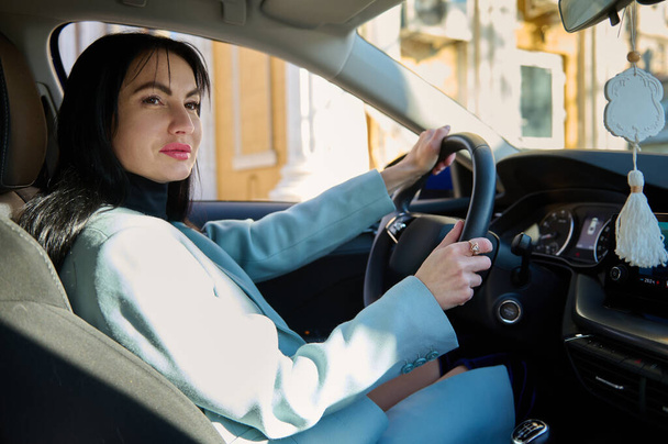 Portrait of happy female driver, beautiful confident middle-aged Caucasian woman, businesswoman, successful entrepreneur in casual wear, steering car with safety belt. People Lifestyle Driving concept - Zdjęcie, obraz