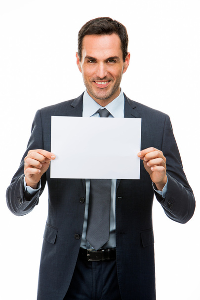 Halve lengte portret van een glimlachende zakenman houden een blanco papier - Foto, afbeelding