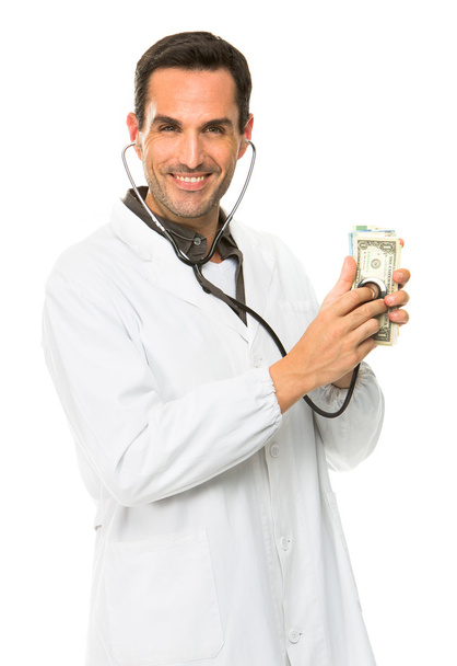 Портрет мужчины-врача, улыбающегося в камеру и использующего стетоскоп на деньги
 - Фото, изображение