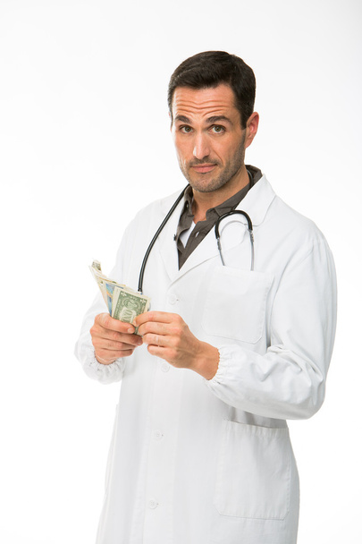 Halve lengte portret van een mannelijke arts met een stethoscoop terwijl tot nu toe geld - Foto, afbeelding