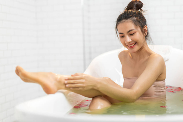 Muotokuva hymyilevä onnellinen kauneus kaunis aasialainen nainen puhdas tuore terve valkoinen iho kylpylä hoito nauttia rentouttavasta suihkussa ja kylvyssä vaahtokylpylä kylpyammeessa kylpyhuoneessa - Valokuva, kuva