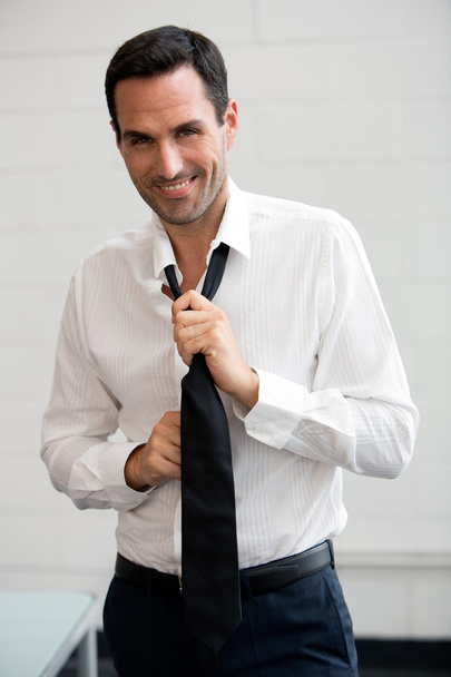 Бізнесмен знімає краватку
 - Фото, зображення