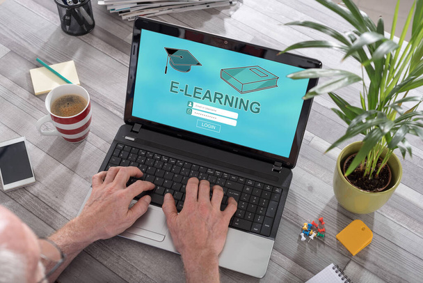 Man using a laptop with e-learning concept on the screen - Photo, Image