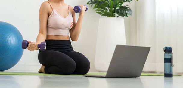 Portrait sport beauty body slim woman in sportswear sitting relax and girl practicing yoga and do fitness exercise with laptop computer in bedroom at home.Diet concept.Fitness and healthy - Photo, image