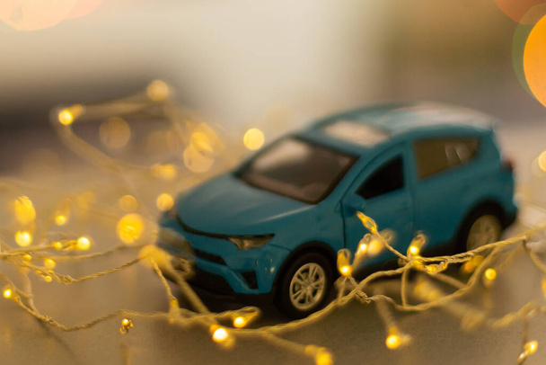 toy car on christmas lights background. new year. - Foto, afbeelding