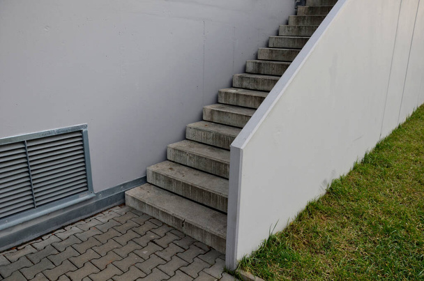wheelchair ramp and stairs on the other side. height differences are tastefully and functionally solved by a retaining wall with a glass railing. city stairs with recessed lights park lawn handlebar - Fotoğraf, Görsel