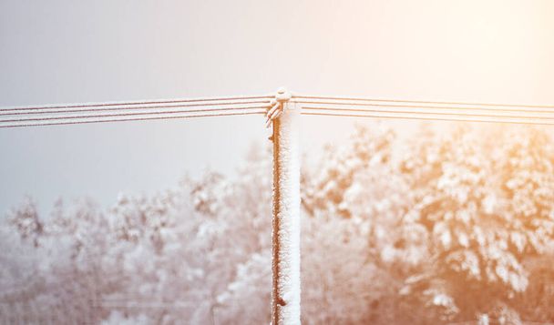 A utility pole and wires are covered with ice. Power outage during a winter snowstorm. - Foto, Imagem