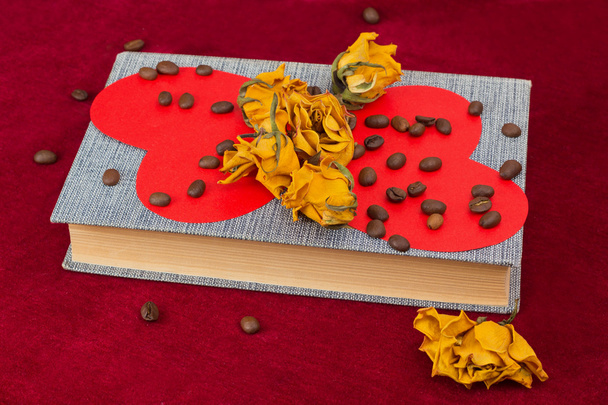 Cinq roses et deux cœurs couchés sur le livre avec des grains de café
 - Photo, image