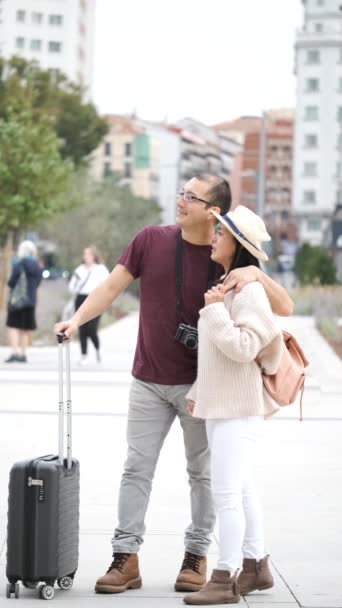 Счастливая многорасовая пара туристов, исследующих город вместе и указывающих на него. Достопримечательности Мадрида, Испания. - Кадры, видео