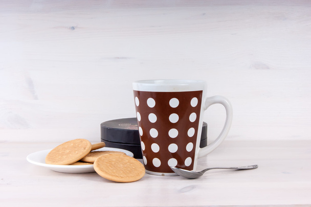 Чашка чая и печенье на белом деревянном фоне
 - Фото, изображение