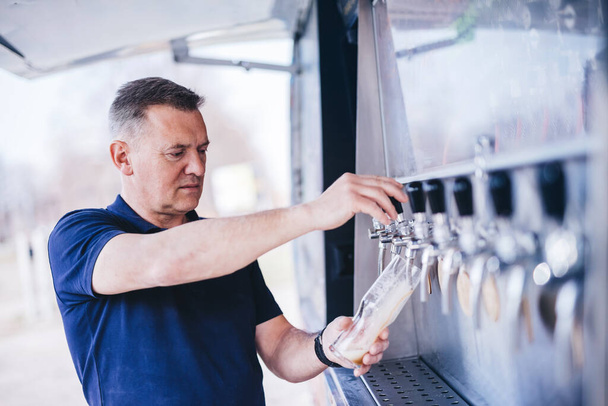 Man tasting craft beer from brewery. Middle-aged business owner, expert. - Foto, Imagem