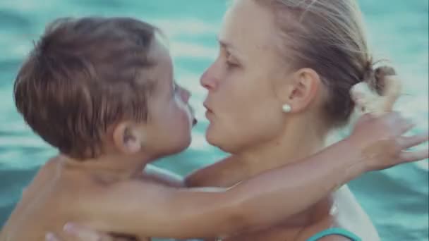 Jongen zoenen moeder tijdens het zwemmen in de zee - Video