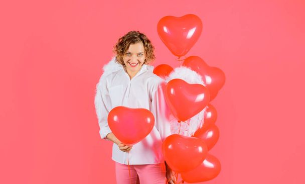 Happy Valentines day. Smiling woman in angelic wings with red heart balloons - Fotoğraf, Görsel