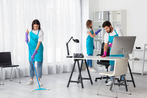 Young janitors cleaning in modern office - Fotoğraf, Görsel