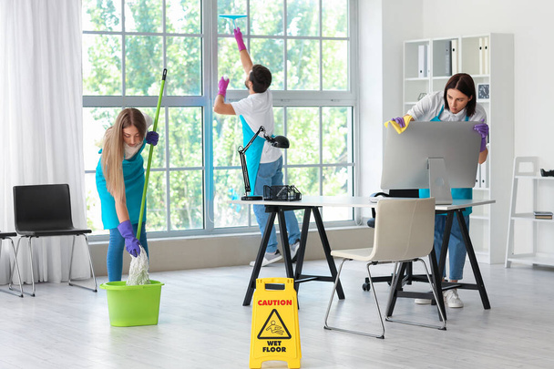 Young janitors cleaning in modern office - Fotografie, Obrázek