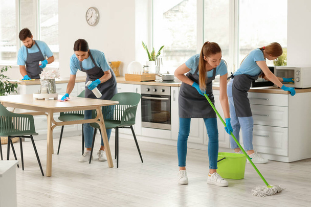Young janitors cleaning in kitchen - Φωτογραφία, εικόνα