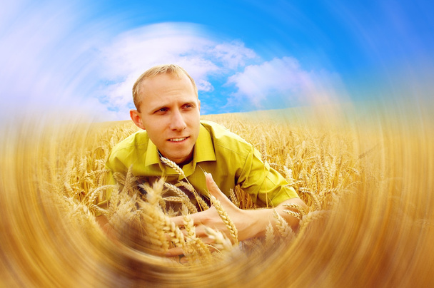 Homem feliz no campo de trigo dourado e céu azul
 - Foto, Imagem
